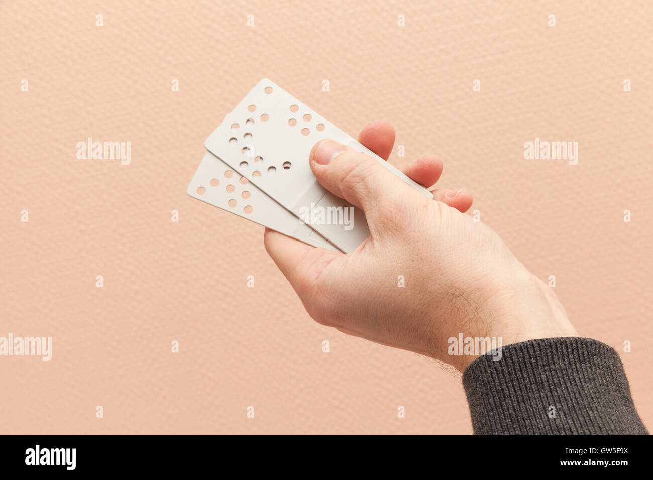 Männliche Hand hält Kunststofftür Key-Cards mit Löchern Kombination code Stockfoto