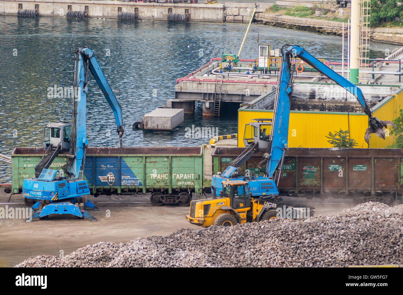 Industrielle Bagger und Eisenbahnwaggons in Odessa Marine Trade Port. Odessa, Ukraine - 22. August 2016. Stockfoto