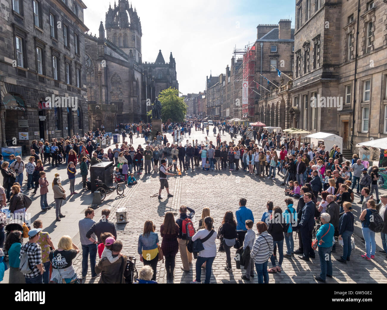 Edinburgh Royal Mile. Edinburgh High Street mit Feuer Interpret und ein Kreis von Besuchern, Touristen auf der Suche. Stockfoto