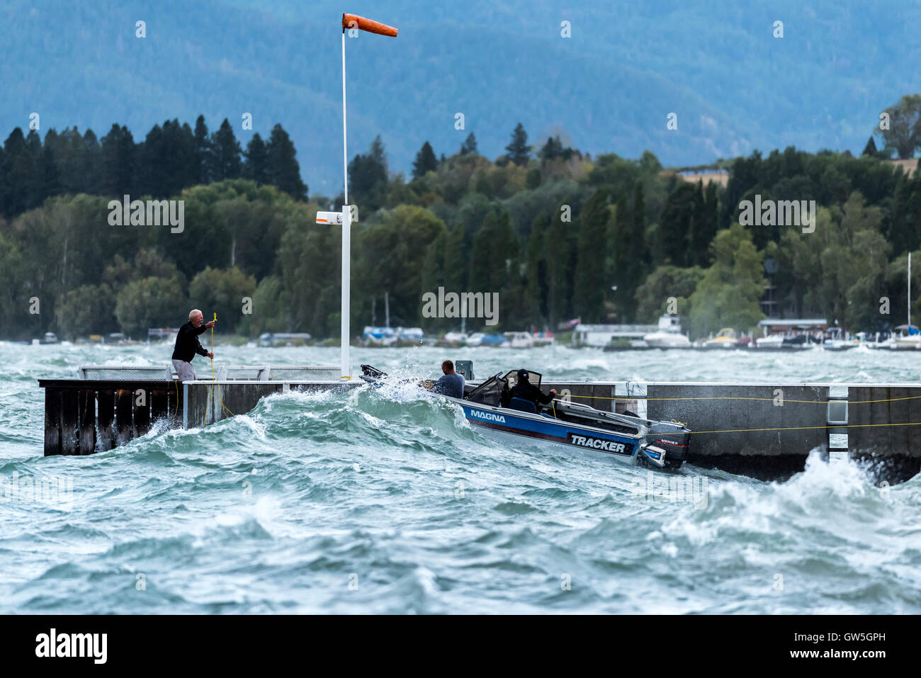 Menschen, die kriechen, um das Boot auf windigen turbulenten Flathead Lake in Montana zu sparen Stockfoto