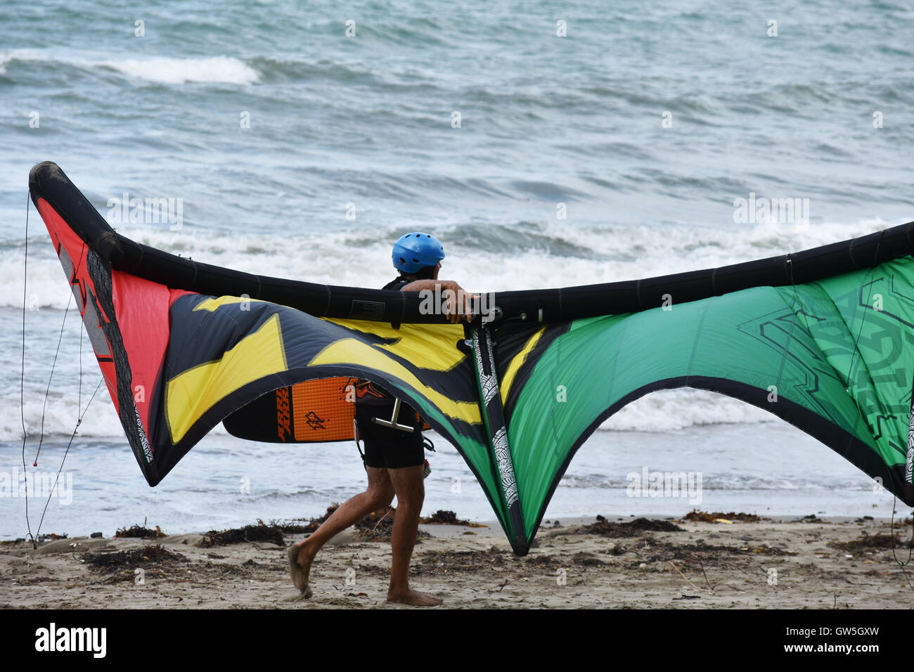 Kitesurfer Helm tragen bunte Drachen am Strand. Stockfoto