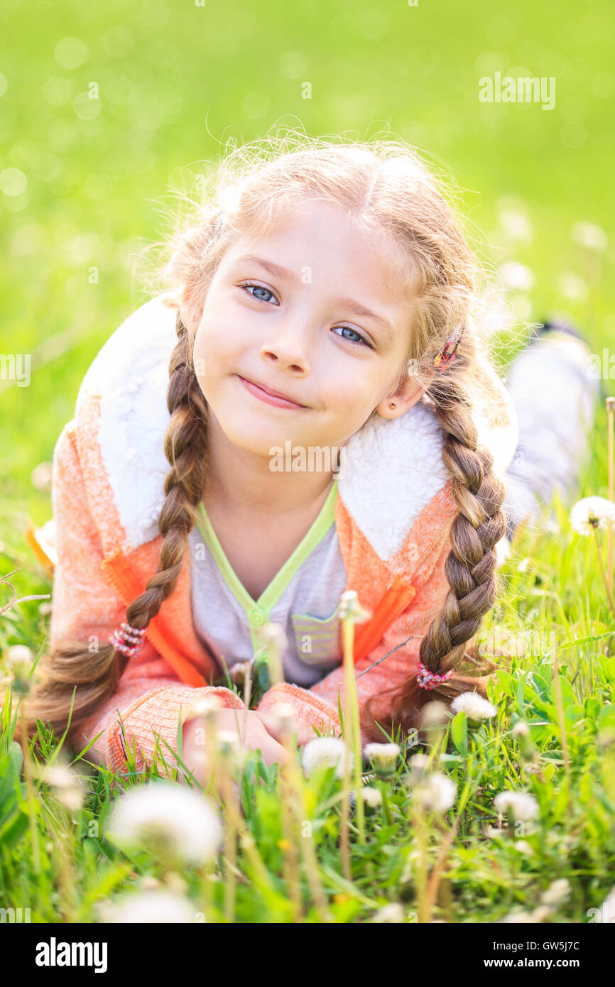 Niedliche kleine Mädchen auf der Wiese im strahlenden Sommertag Stockfoto
