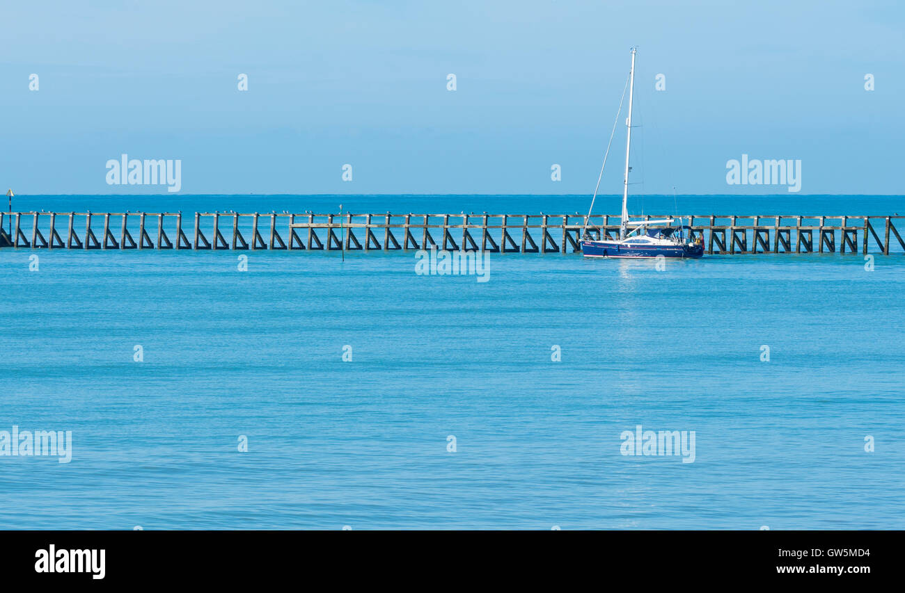 Ruhiges Meer. Yacht verlassen eine Flussmündung auf einem ruhigen flache blaue Meer. Stockfoto