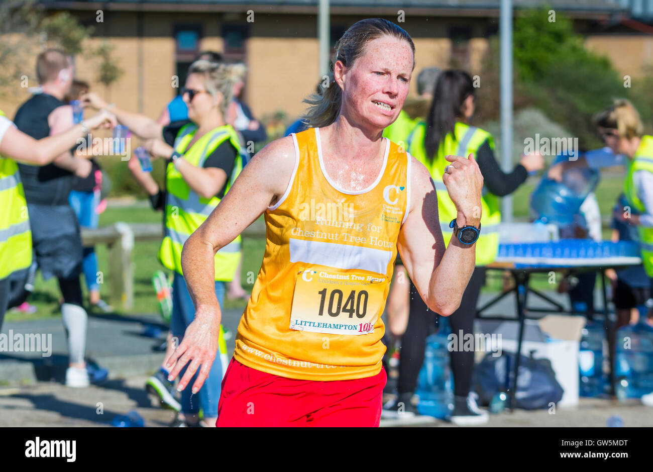 Heiß und verschwitzt weibliche Läufer bei einem Sponsorenlauf erschöpft. Stockfoto
