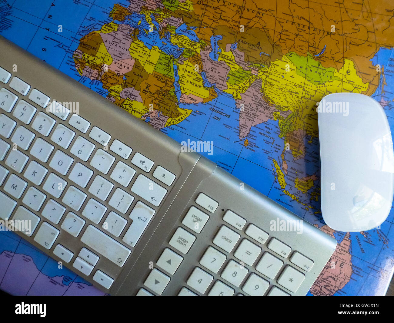 Tastatur und Maus auf Weltkarte am Schreibtisch Stockfoto