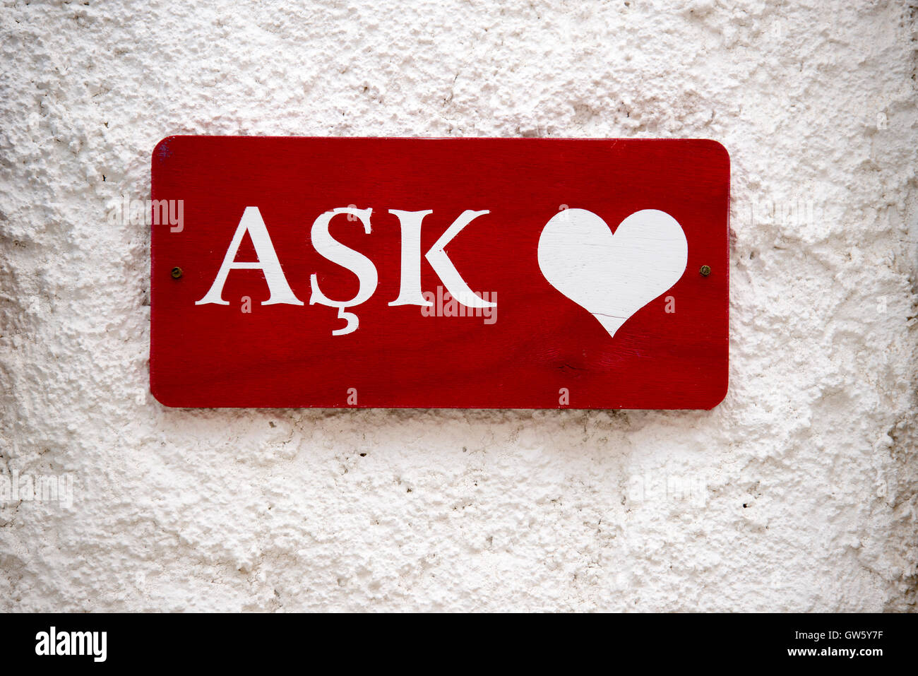 Liebe Wort in türkischer Sprache auf einem roten Holz und weißen Buchstaben an der Wand. Stockfoto