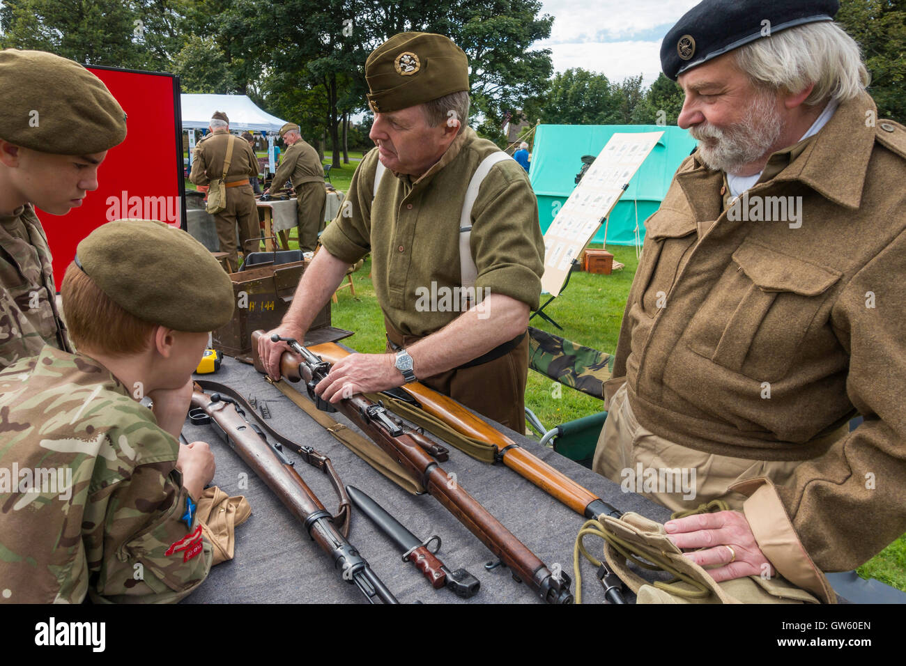 Ein 40er Jahre Heritage Day mit alten Soldaten zeigen, wie man eine Gewehr, Armee-jüngstere Söhne laden Stockfoto