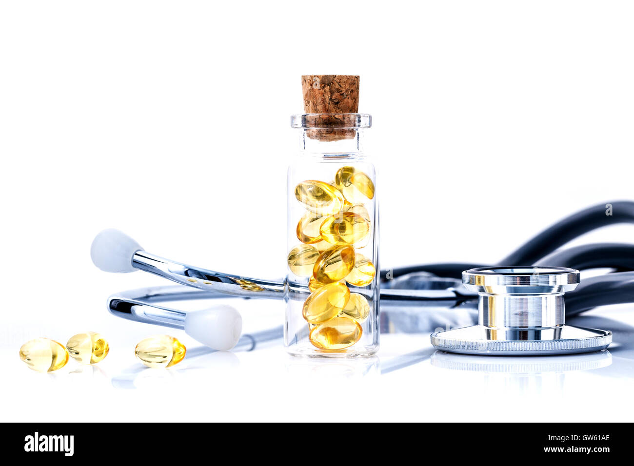 Fischölkapseln in Flasche mit Stethoskop isoliert auf weißem Hintergrund. Fisch Öl Ergänzung Kapsel Quelle von Omega-3. Stockfoto