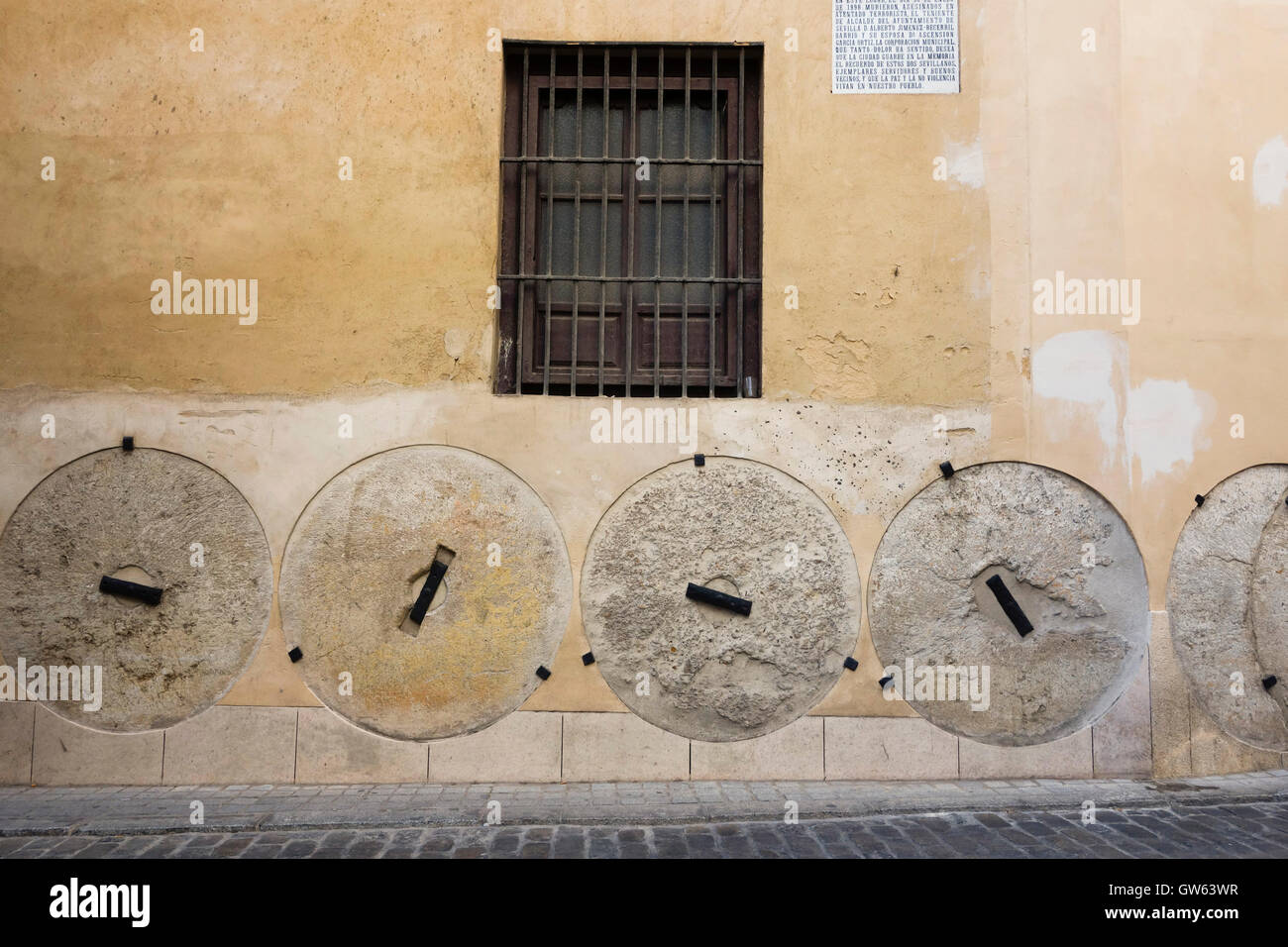 Mühle Steinen, Mühlsteine eingebettet in Wand zum Schutz von Kutschen, Stadtzentrum entfernt. Sevilla, Andalusien, Spanien. Stockfoto