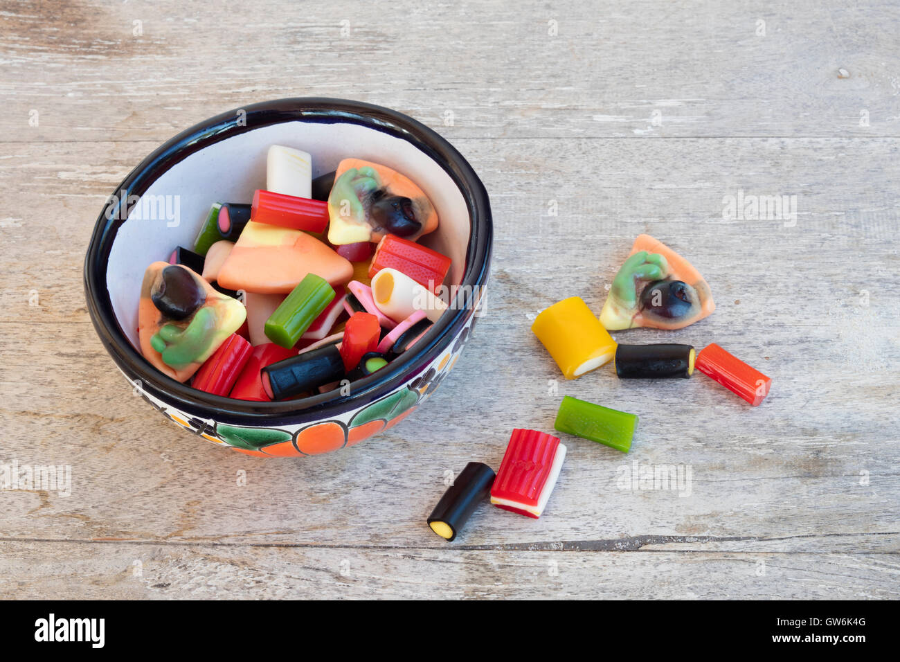Schale mit bunten Gummibärchen Gelees und Süßigkeiten auf einem Holztisch Stockfoto
