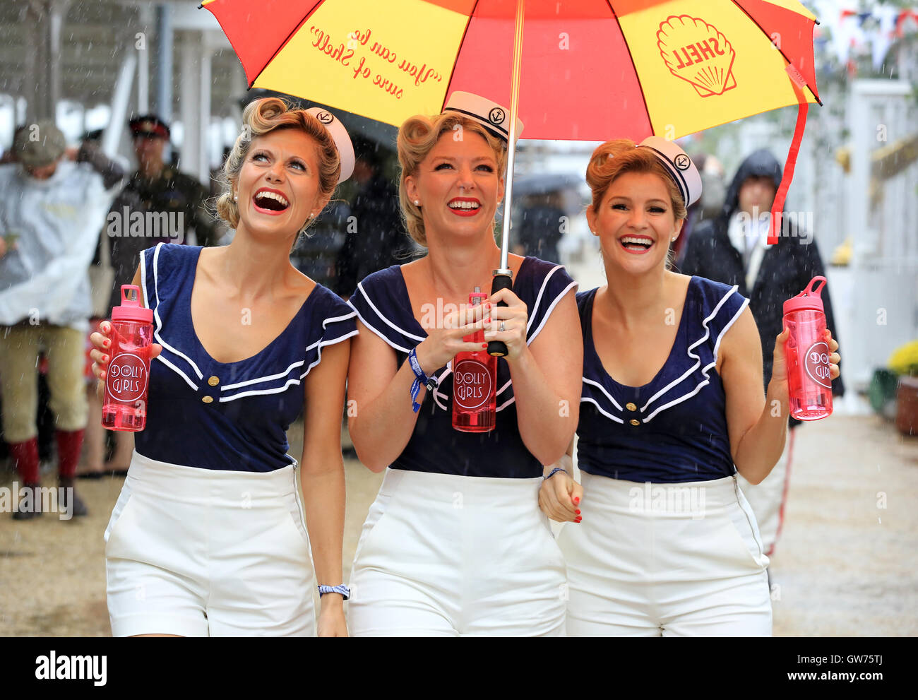 Die Dolly-Mädchen (l-R Hannah Woolley, Helen Patching, Katy Osborne, aus London), ein enger Harmonie Vintage Trio, in Vintage Seemann Outfits gekleidet sind abgebildet, während die Nässe beim Goodwood Revival.   Das Goodwood Revival ist eine dreitägige Festival jedes Jahr im September im Goodwood Circuit seit 1998 für die Arten von Straßenrennen Autos und Motorrad, die in der Schaltung original Zeitraum teilgenommen haben würde – 1948 – 1966. Stockfoto
