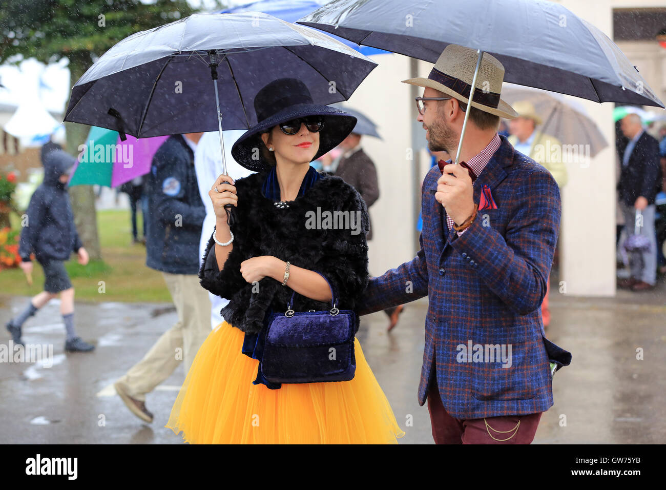 Besucher in das schlechte Wetter, während im Zeitraum Kleid beim Goodwood Revival Vormittag abgebildet. Stockfoto