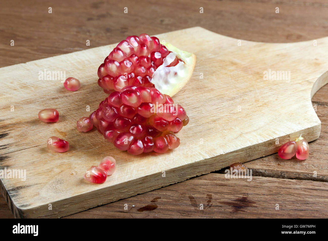 Granatapfel-Frucht-Schnitt sezieren auf hölzernen Hintergrund. Stockfoto