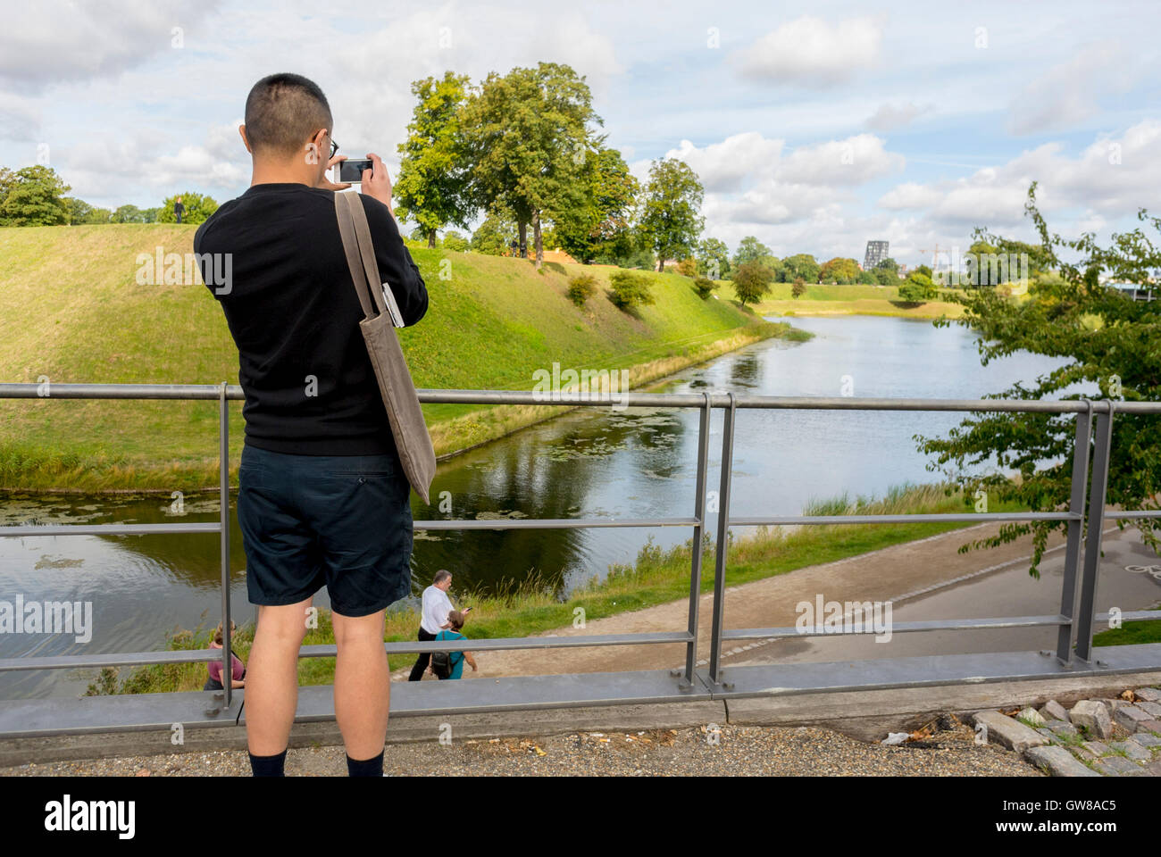 Kopenhagen, Dänemark, Europa Chinesische Touristen Besuch der Zitadelle, Fotografieren mit dem Smartphone, Mann mit dem iPhone außerhalb des Langelinie Parks Stockfoto