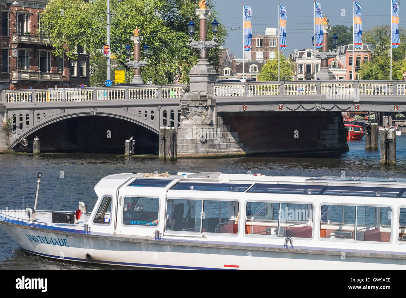Das Amstel Jade Lesiure Boot auf dem Fluss Amstel Blauwbrug Bridge, Amsterdam, Niederlande. Stockfoto