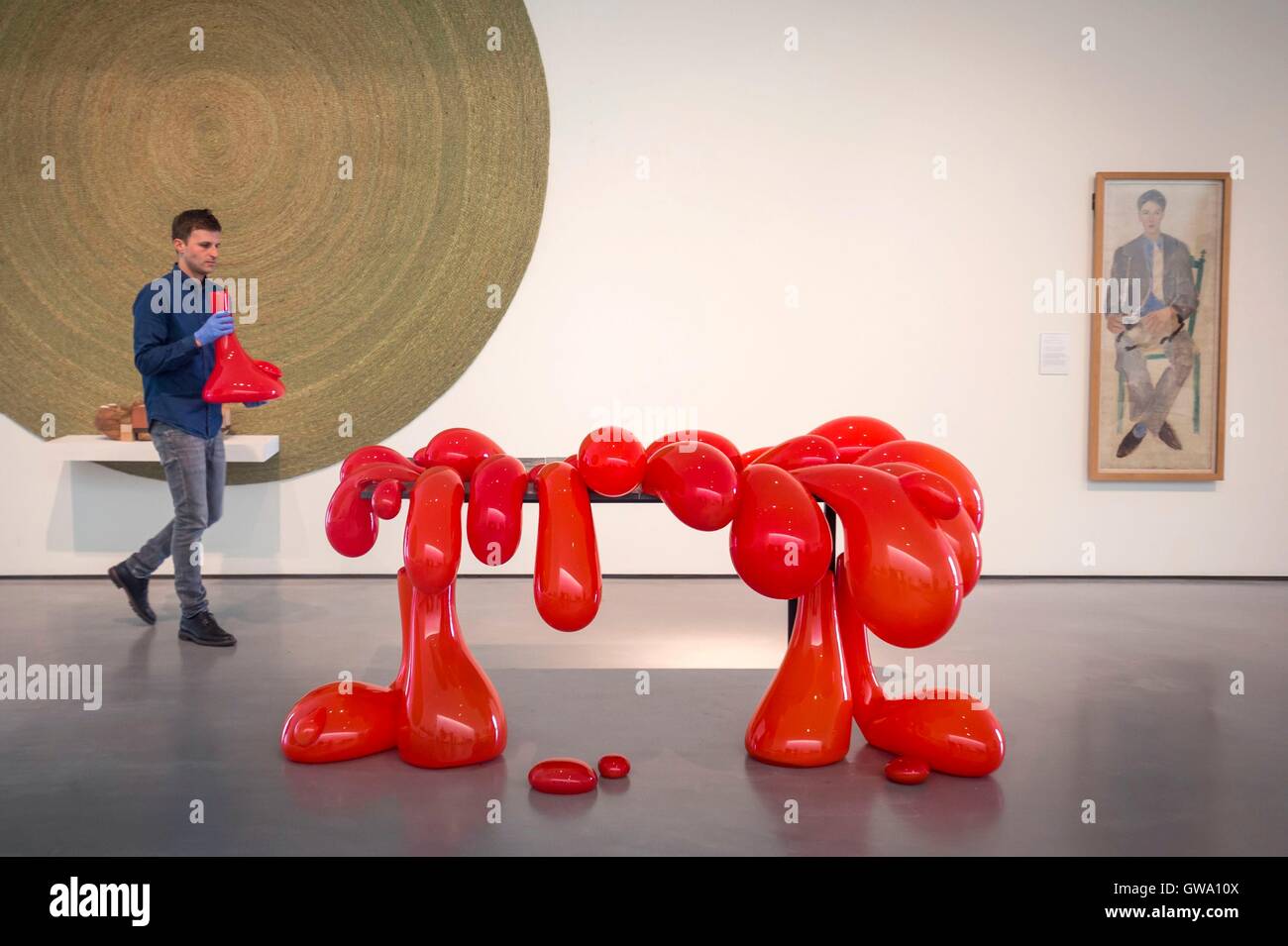 Chief Curator Andrew Bonacina mit Vulcano Tisch, 2014 (Blown Glas, Ferrari-rot Pigment, Kalksteinfliesen, pulverbeschichtetem Metall) von Turner Preis nominierten Anthea Hamilton, wie er den letzten Schliff für des Wasserkochers Hof Romanfigur ausdrückt: Anthea Hamilton Ausstellung in The Hepworth Wakefield vom 15. September 2016 bis 19. März 2017. Stockfoto