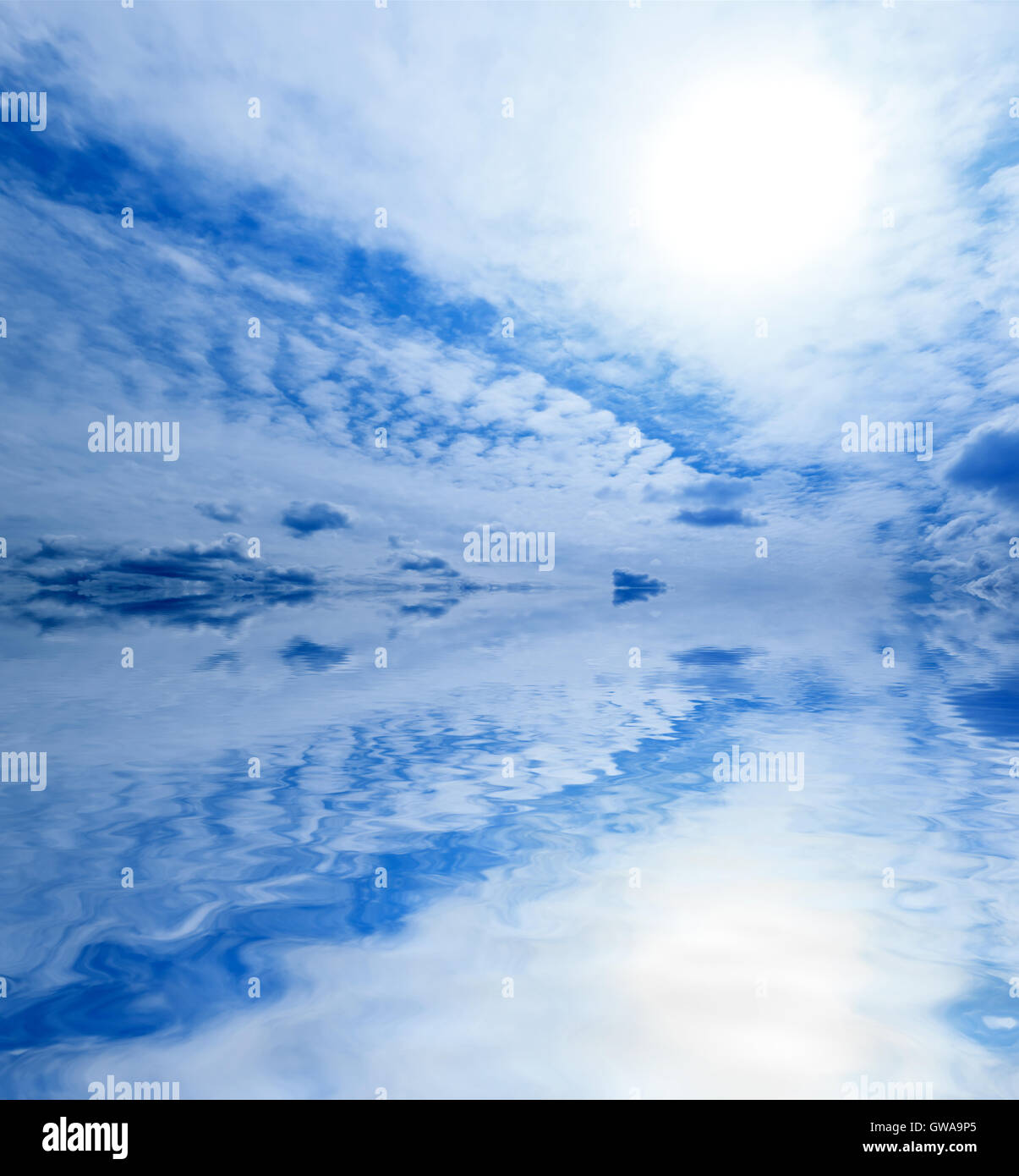 Leichte blaue abstrakte Himmel und Ozean Hintergrund: helle Sonne und Wolken Muster spiegelt sich in welligen Wasseroberfläche Stockfoto