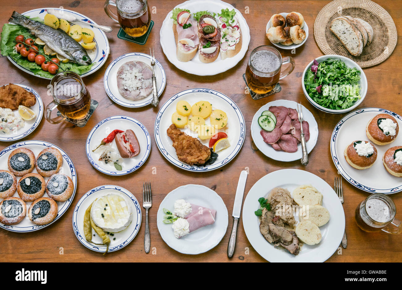 Essen von oben auf einen Holztisch mit jungen Menschen auf eine Vielzahl von Lebensmitteln zu essen Stockfoto