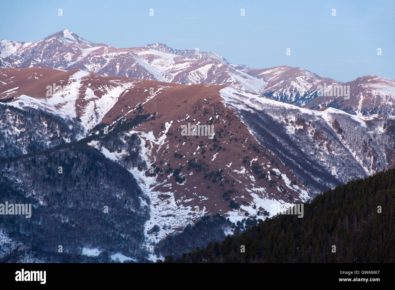 Wintermorgen in Arkhyz (Russland) mit Pisten in den Bergen mit Schnee bedeckt und Gipfel steigen durch Sonnenlicht. Stockfoto