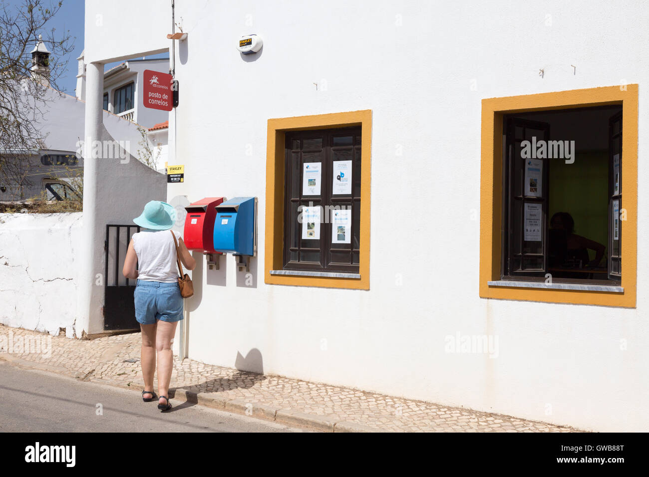 Eine Frau, die Entsendung eines Briefs beim Postamt Dorf, die Algarve, Süd-Portugal, Europa Stockfoto