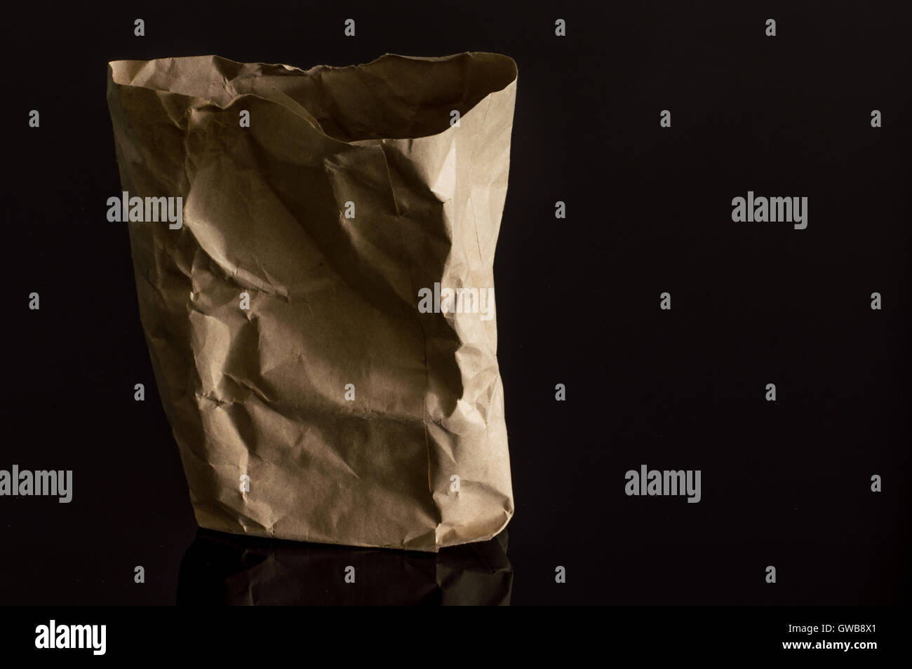 Braune Papiertüte auf dunklem Hintergrund isoliert Stockfoto