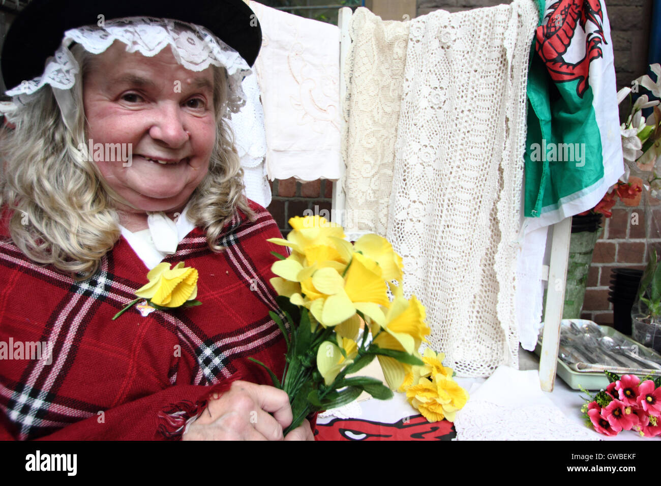 Blumenverkäuferin, Gwen Rodgers trägt, wie traditionelles walisisches an ihrem Stand in Abergavenny Markt, Abergavenny, Monmouthshire, Wales zu kleiden Stockfoto