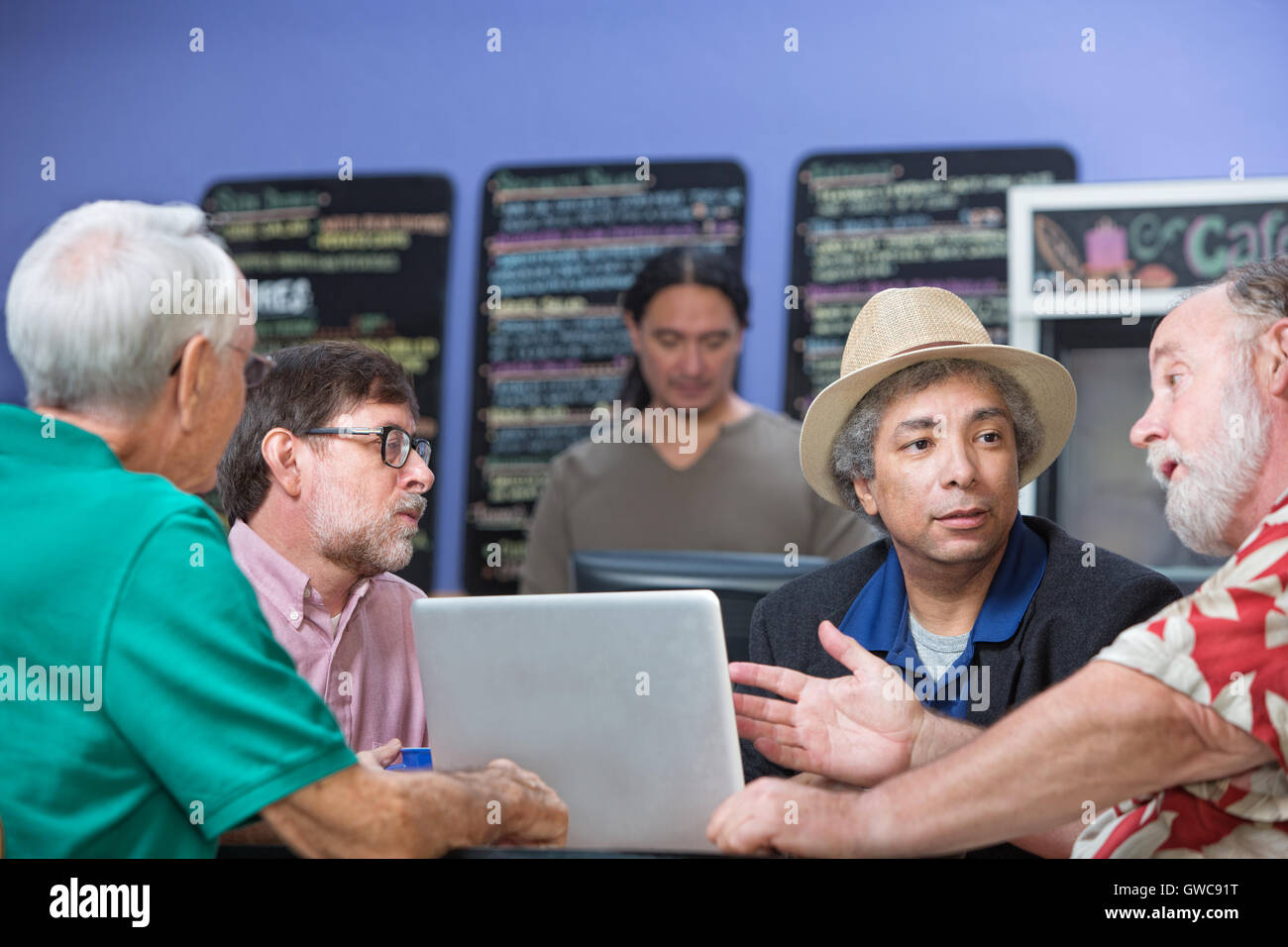 Mann im Gespräch mit Freunden im Cafe Stockfoto