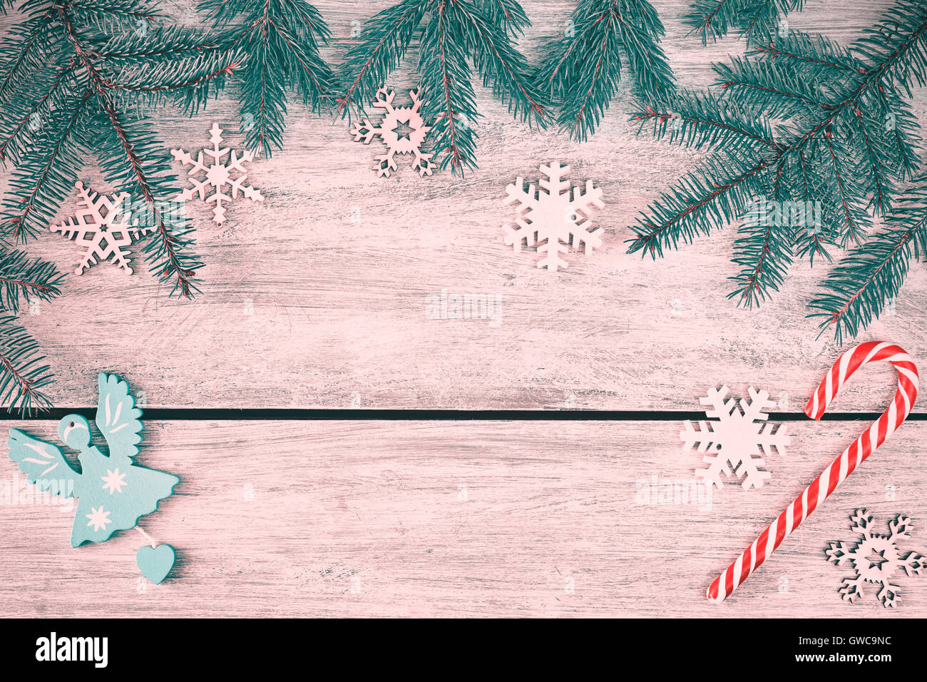 Retro stilisierte Weihnachten Hintergrund, Fichte Zweige mit Verzierungen auf einem rustikalen Holztisch, Ansicht von oben mit Textfreiraum. Stockfoto