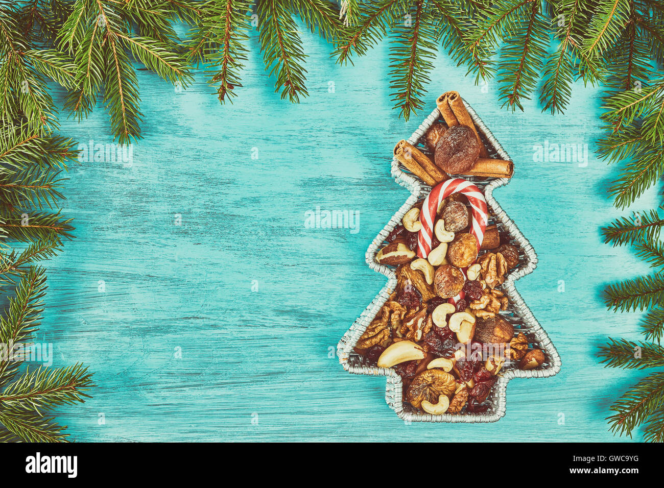 Retro-stilisierten Weihnachtsbaum geformte Behälter gefüllt mit Nüssen und getrockneten Früchten auf einem rustikalen Holztisch, Ansicht von oben mit kopieren sp Stockfoto