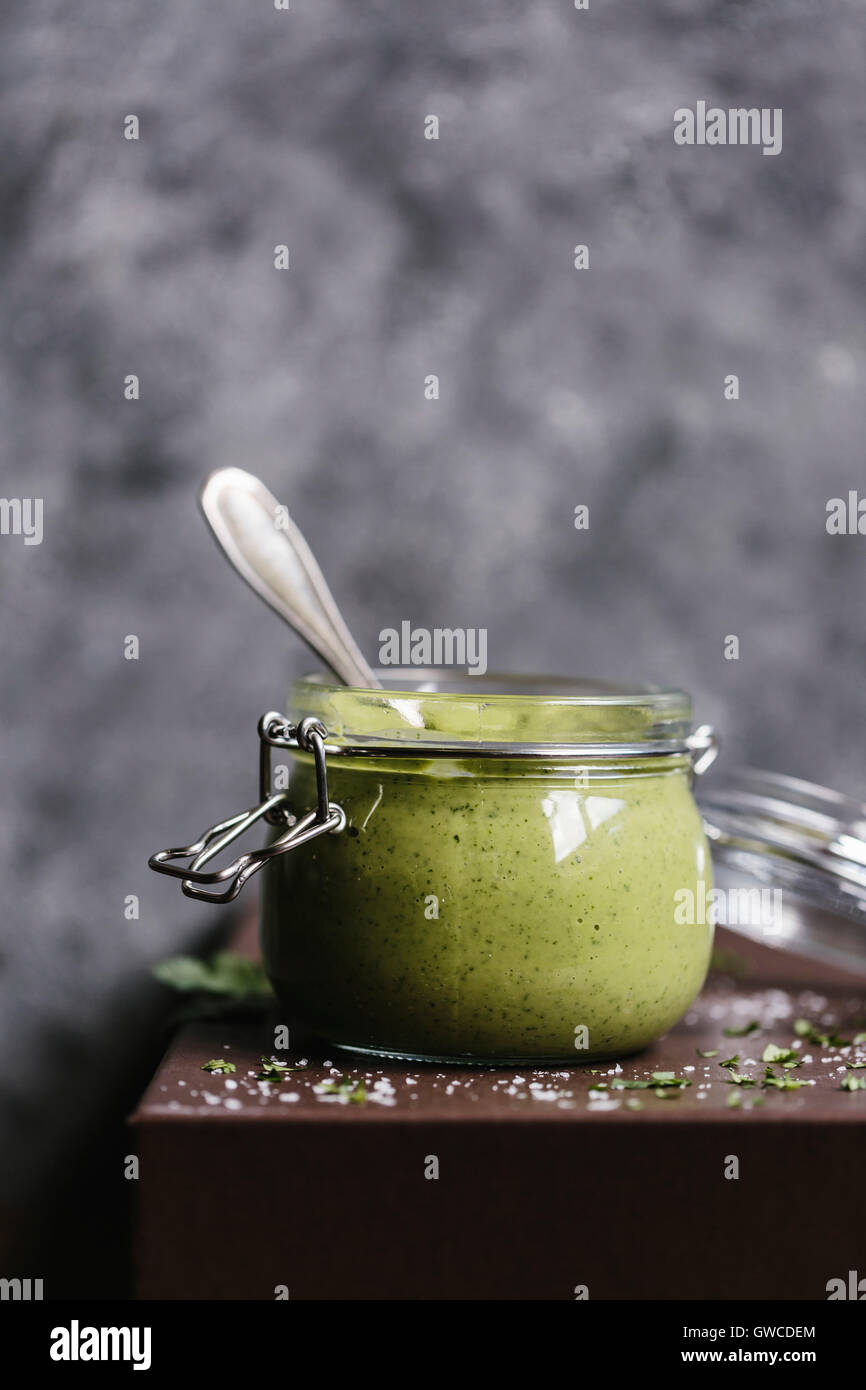 Ein Glas mit cremigen Avocado Salat-Dressing wird aus der Vorderansicht fotografiert. Stockfoto
