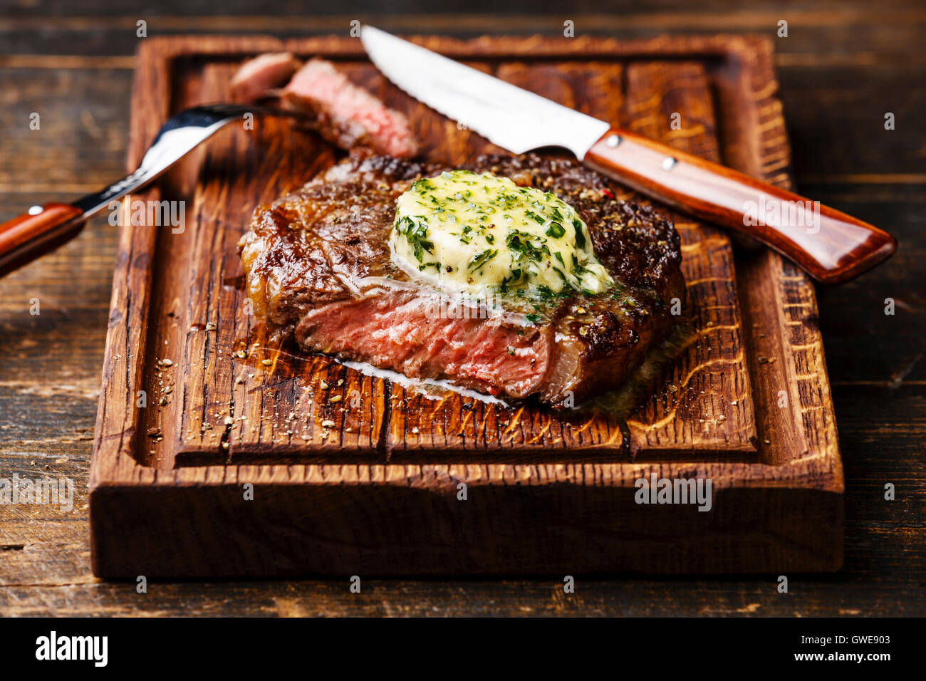 Gegrillt Medium rare Steak Ribeye mit Kräuterbutter auf Schneidebrett Stockfoto