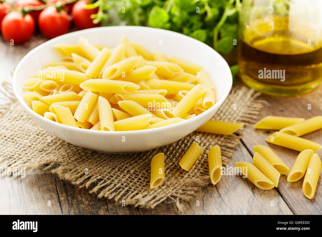 Penne - rohe italienische Pasta in eine kleine Schüssel geben  Stockfotografie - Alamy