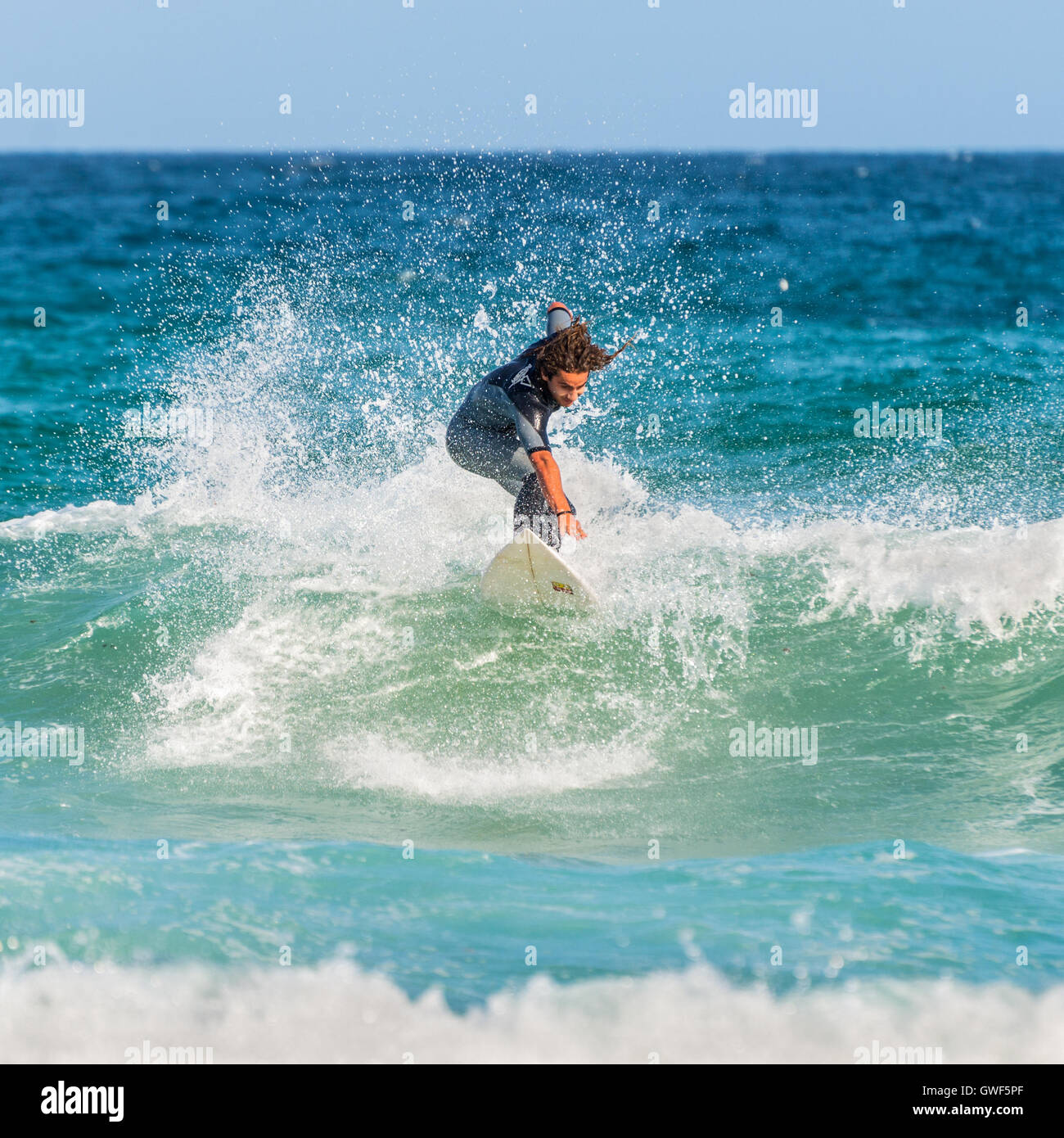 Ein Mann reitet auf seinem Surfbrett in Richtung Ufer. Berühmten Bondi Beach bietet eine breite Palette an Sport- und Freizeitaktivitäten. Stockfoto