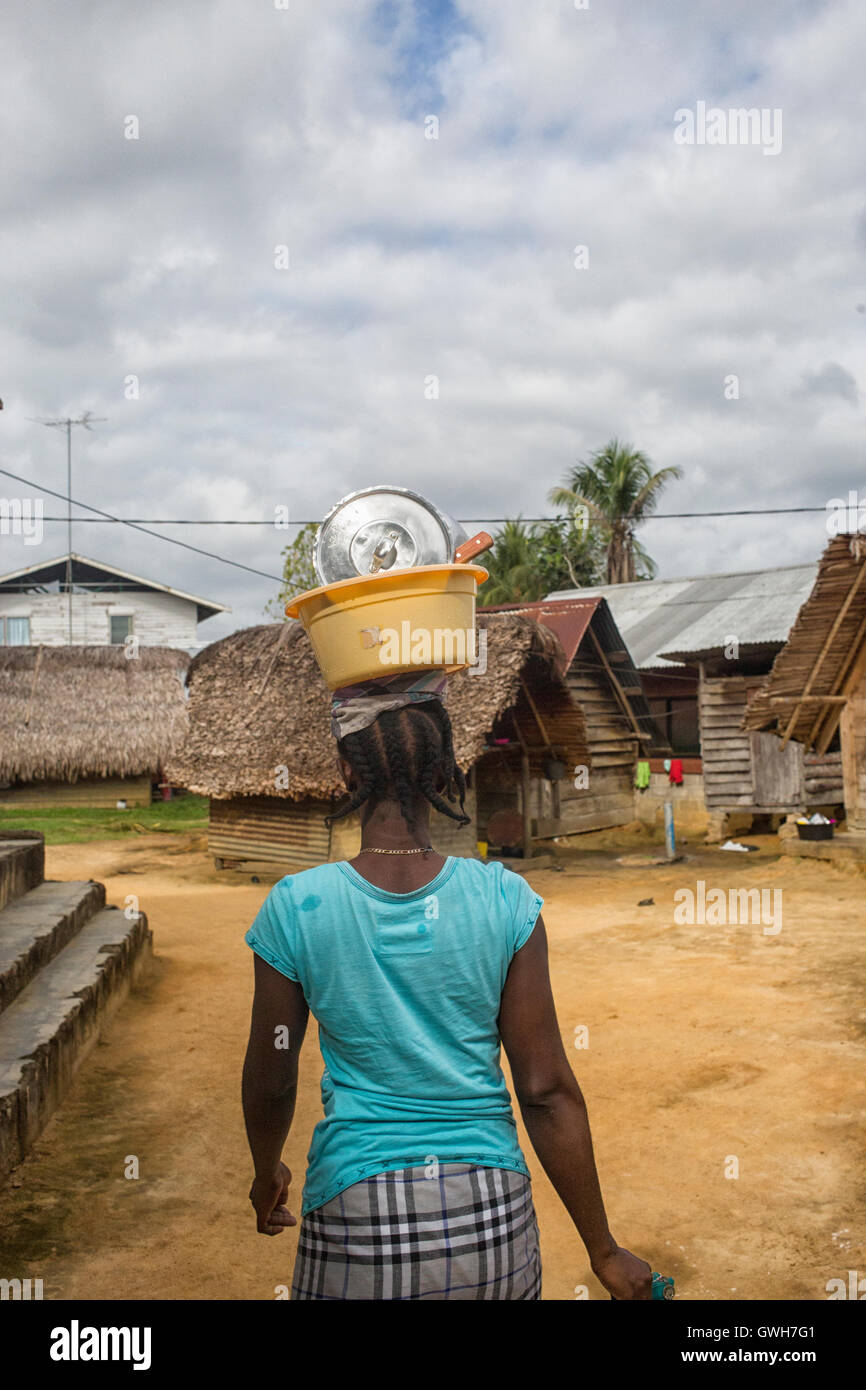 Frau, die Schüssel mit Gerichten auf ihren Kopf in Suriname Maroon Stockfoto