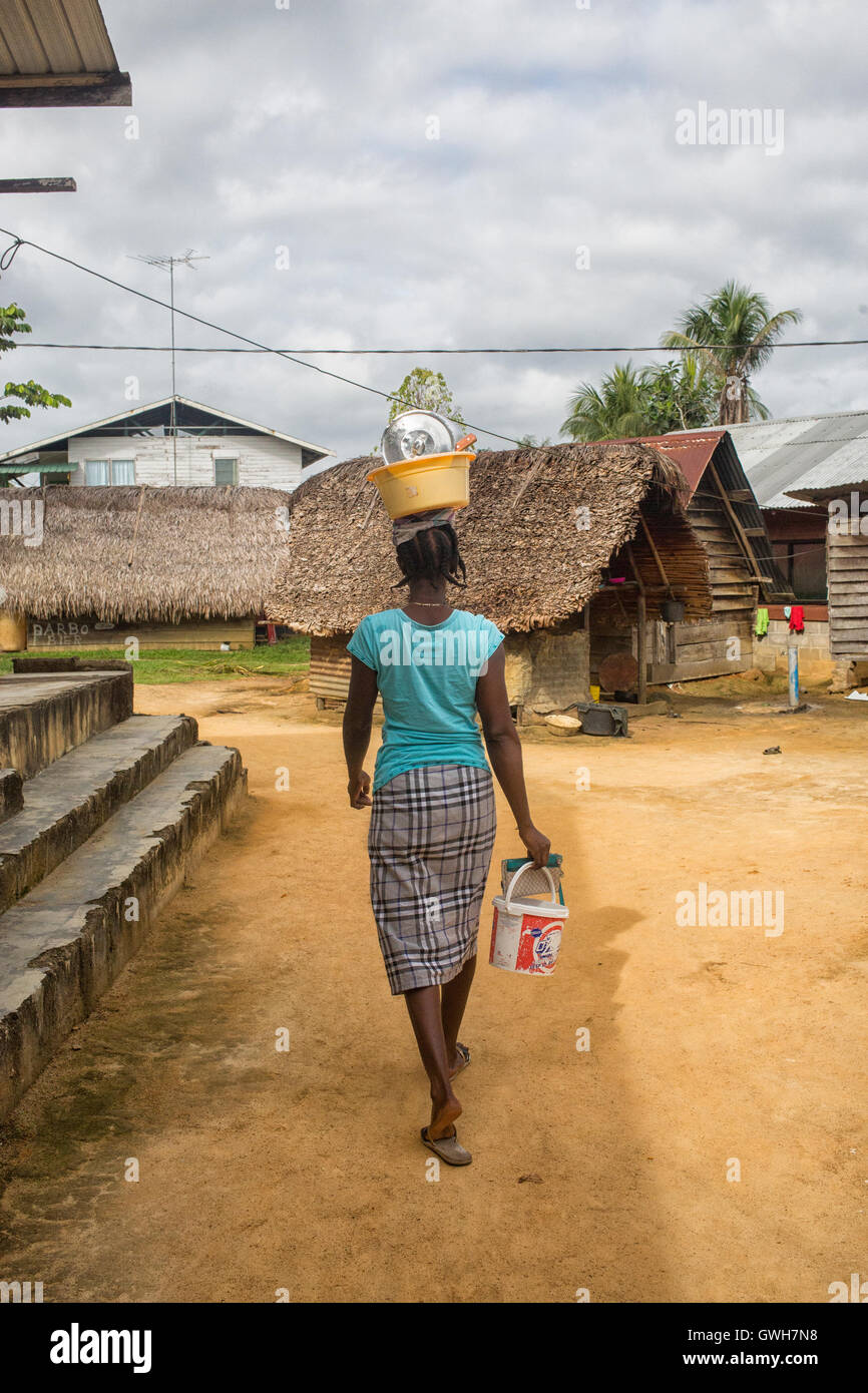 Frau, die Schüssel mit Gerichten auf ihren Kopf in Suriname Maroon Stockfoto