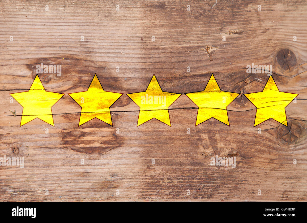Fünf Sterne Ranking auf hölzernen Hintergrund gelb Stockfoto