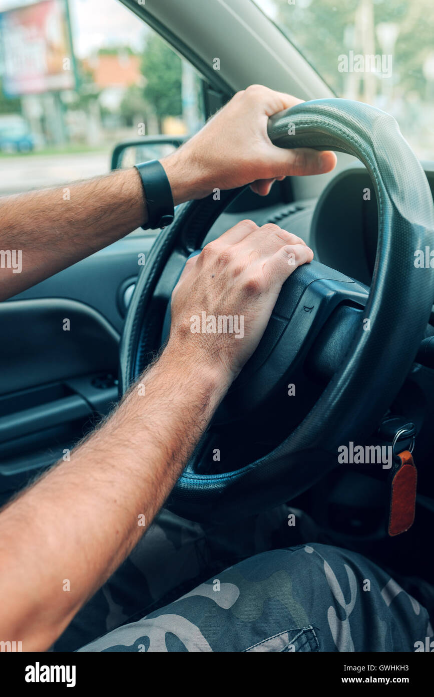 Nervös männliche Fahrer schieben Autohupe Traffic Rush hour, hautnah mit selektiven Fokus auf Hand am Lenkrad Stockfoto