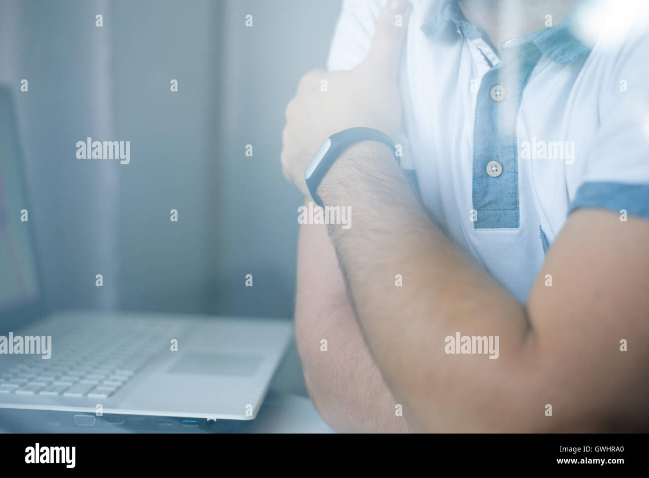 Nahaufnahme des Mannes mit Fitness-Tracker im Büro durch Glasfenster Stockfoto