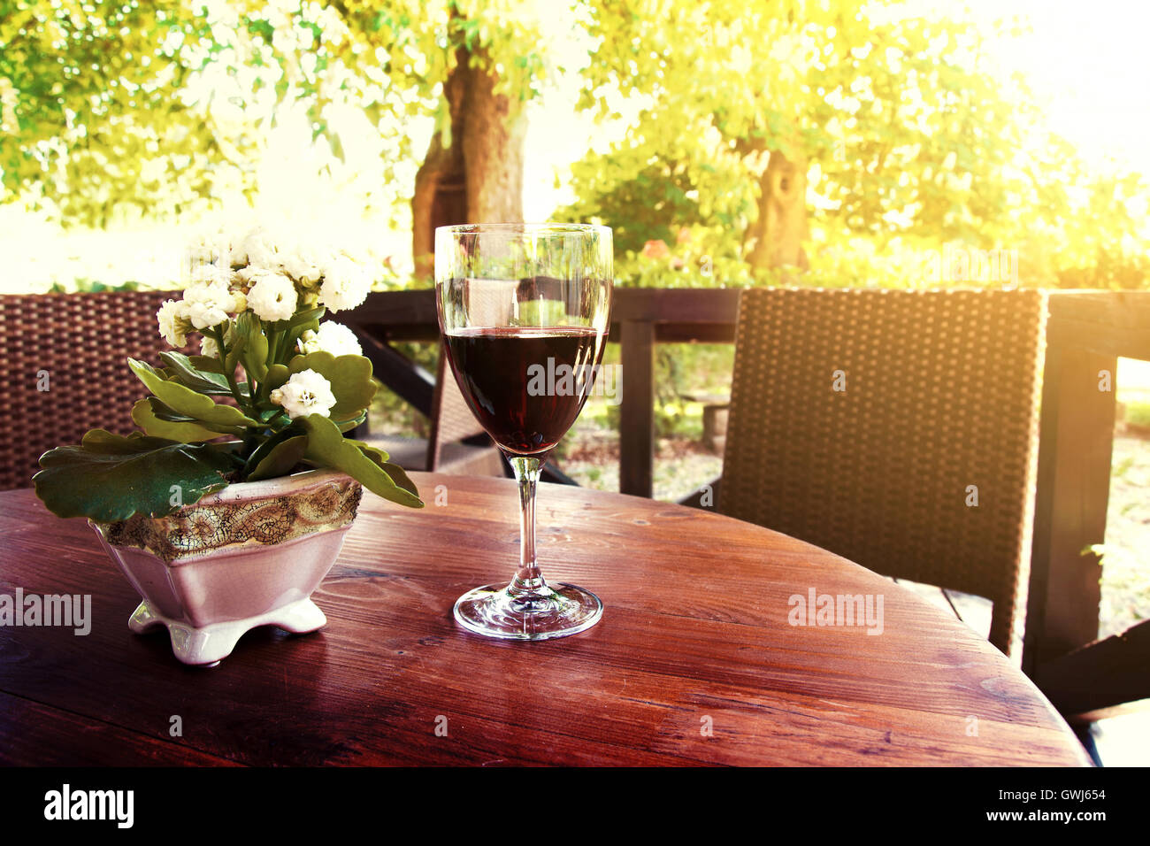 Rotwein auf dem Tisch im idyllischen Innenhof im Restaurant im Sommer. Konzept zu trinken. Stockfoto