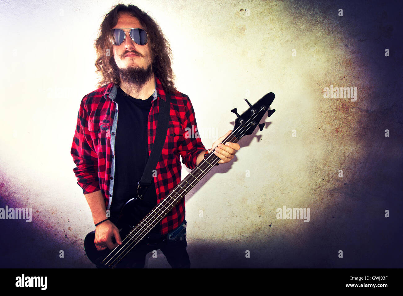 Gitarrist, Bass-Gitarre zu spielen. Retro-Instagram Vintage Grunge Bild. Stockfoto