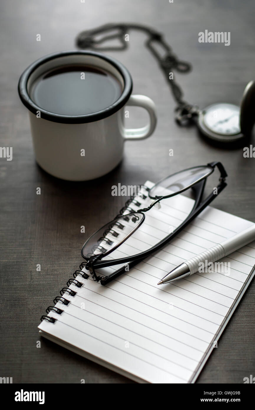 persönlicher Schreibtisch mit Kaffee, Notebook und beobachten Stockfoto