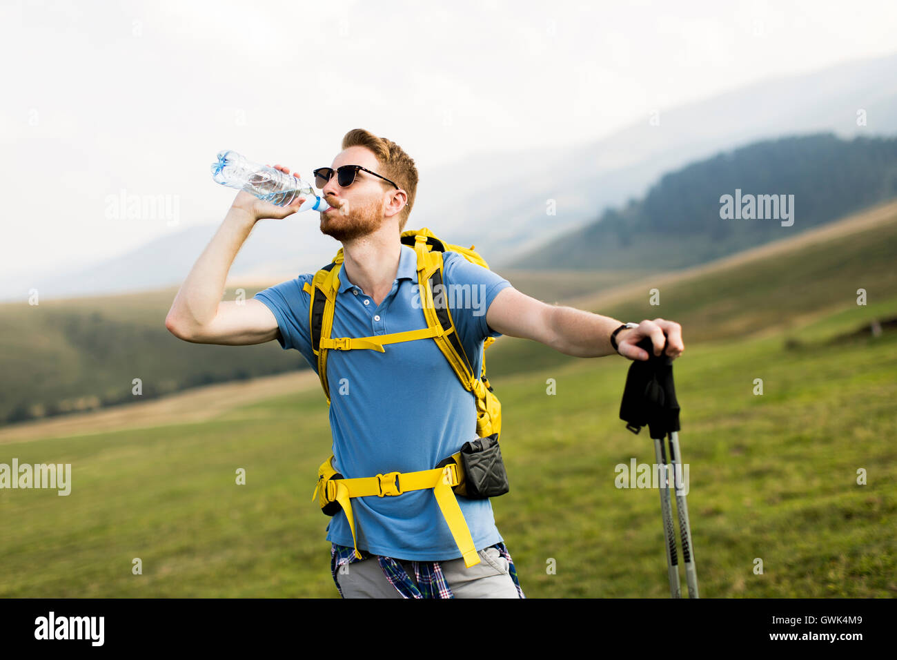 Junge Wanderer gestoppt und trinken Wasser aus einer Flasche Stockfoto