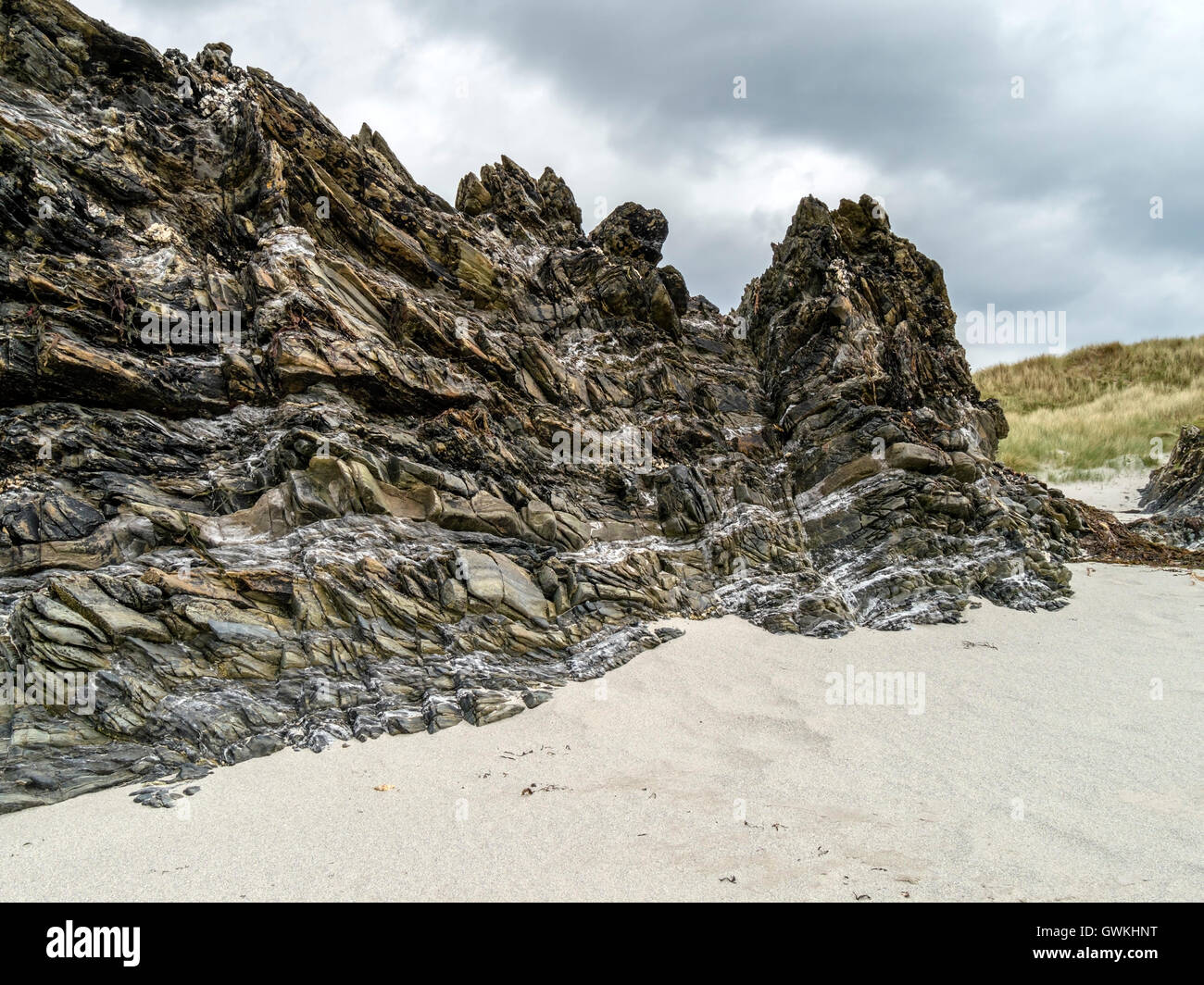 Felswand Felsvorsprung am Sandstrand, Plaide Mhor, Ardskenish, Insel Colonsay, Schottland, Vereinigtes Königreich. Stockfoto
