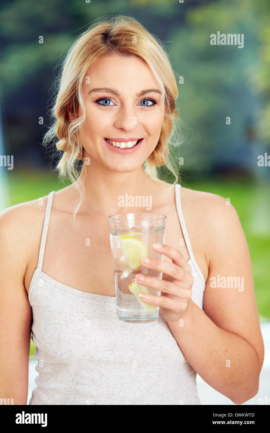 Mädchen trinken Glas Eiswasser mit Zitrone Stockfoto