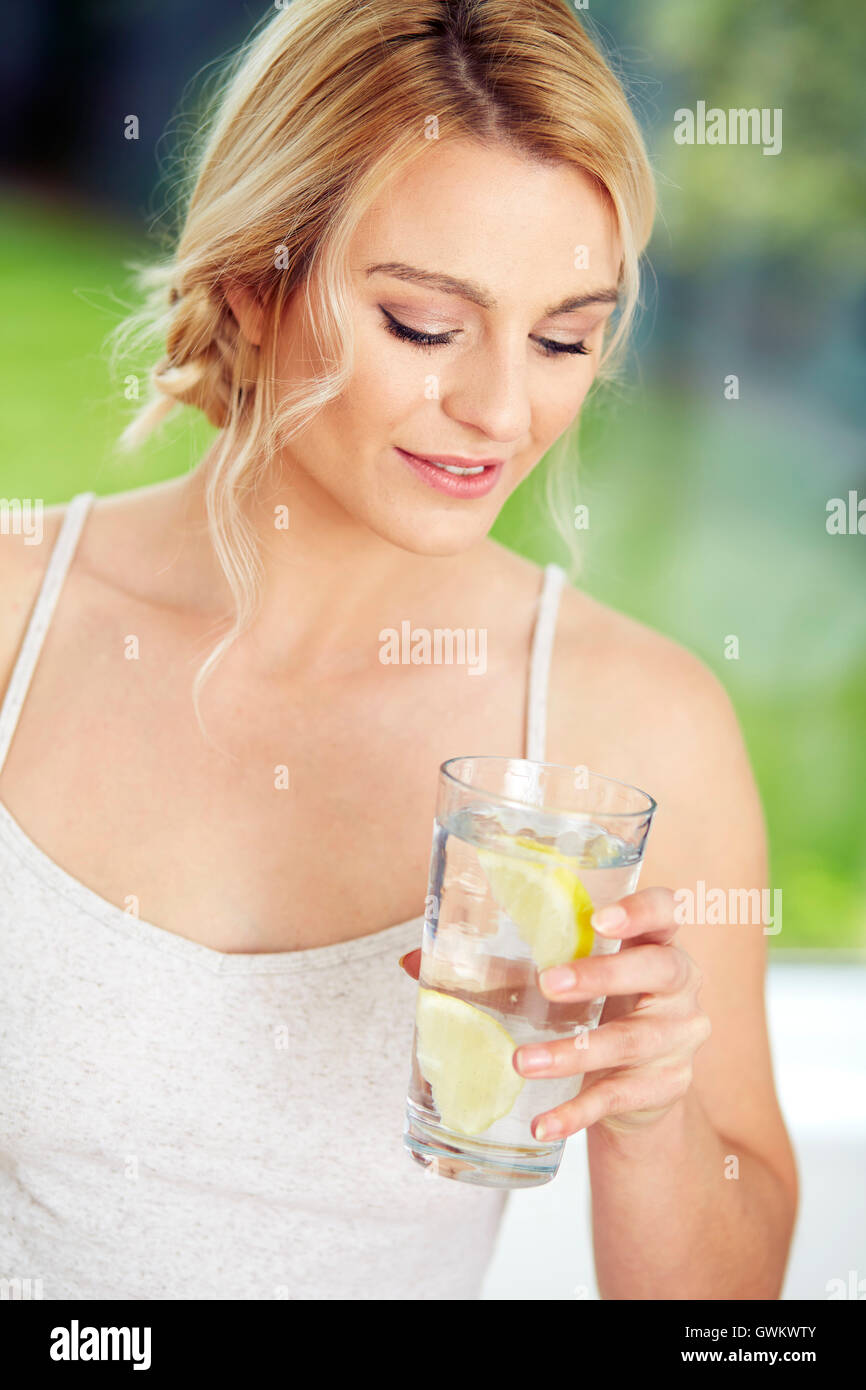 Mädchen trinken Glas Eiswasser mit Zitrone Stockfoto