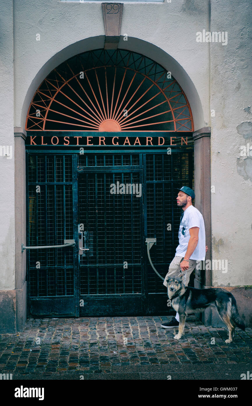 Ein Mann und sein Hund stehend außerhalb Klostergaarden Eigentumswohnung,  Kopenhagen, Dänemark Stockfotografie - Alamy