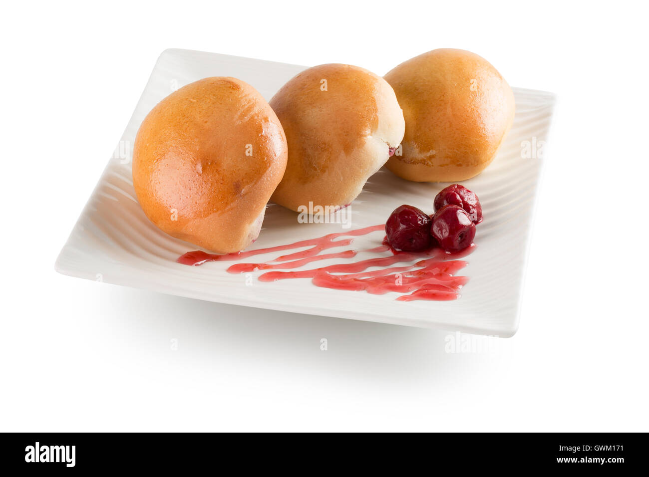 Pastetchen mit Kirschen auf weißem Teller auf dem weißen Hintergrund isoliert. Stockfoto