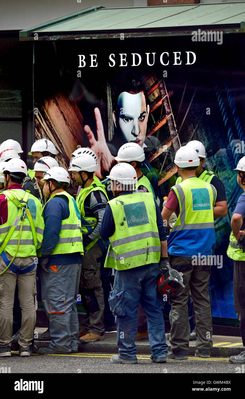 London, England, Vereinigtes Königreich. Arbeiter vor einem Phantom der Oper-Werbeplakat Stockfoto