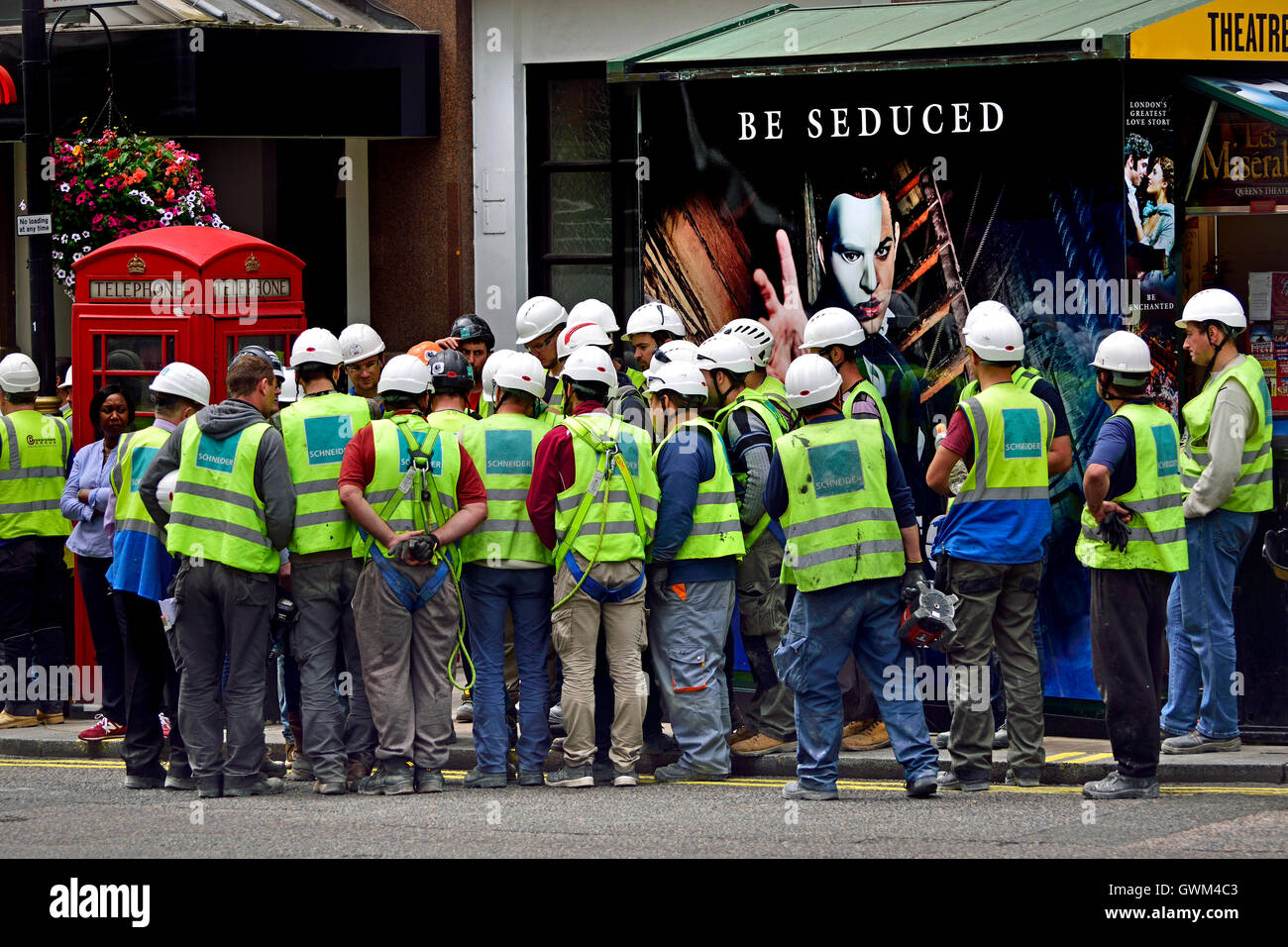 London, England, Vereinigtes Königreich. Arbeiter vor einem Phantom der Oper-Werbeplakat Stockfoto