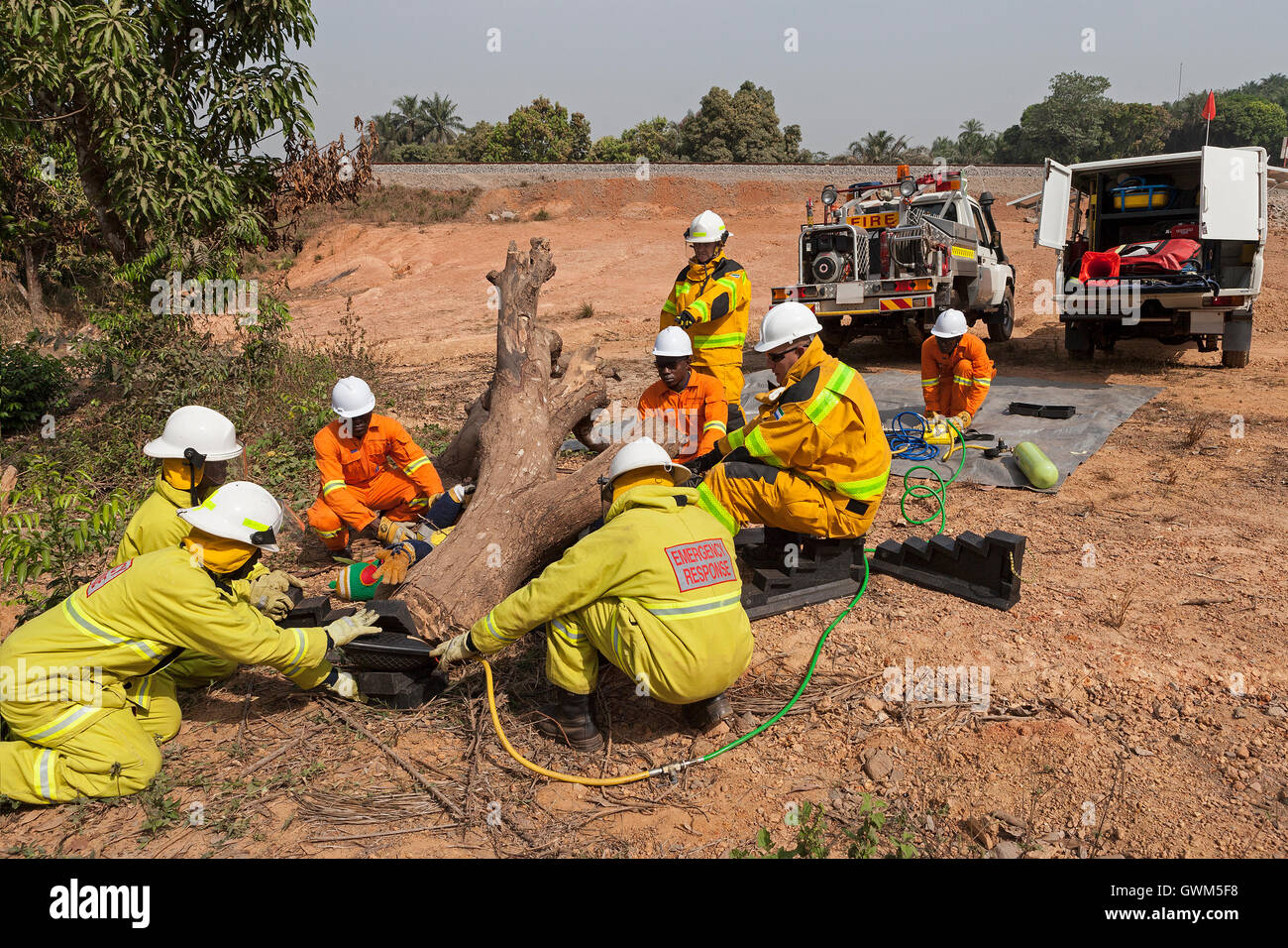Beschäftigte aus Sierra Leone von Emergency Response Team auf Eisenerz Projekt, die sich einer pneumatischen Hebezeugen Ausbildung am Patienten unter Baum eingeklemmt Stockfoto